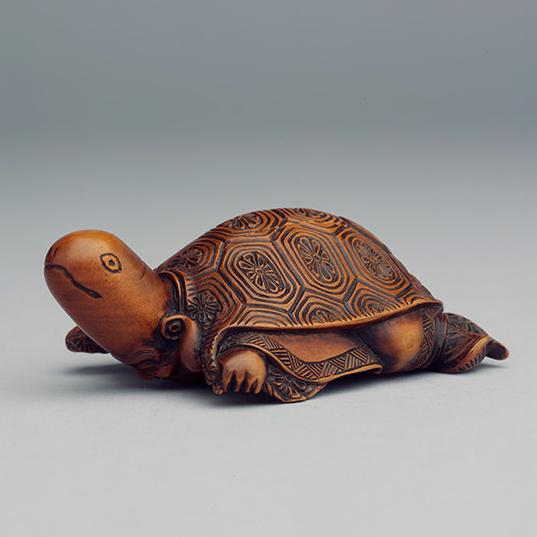 YPM ANT 231941-c: Carved wood dual statuette. Horizontally a tortoise; stand, the figure of an immortal.  Japan