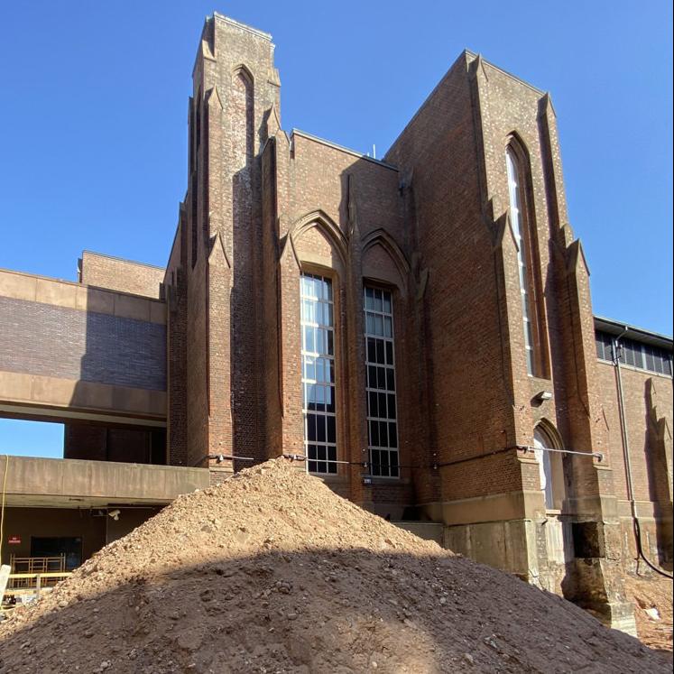 A large pile of dirt facing a tower of the Museum