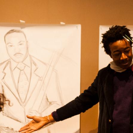 The artist in conversation with visitors gestures to his portrait of Dr. King.