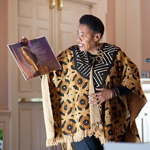 A presenter reading a book to an audience at a New Haven Museum family event